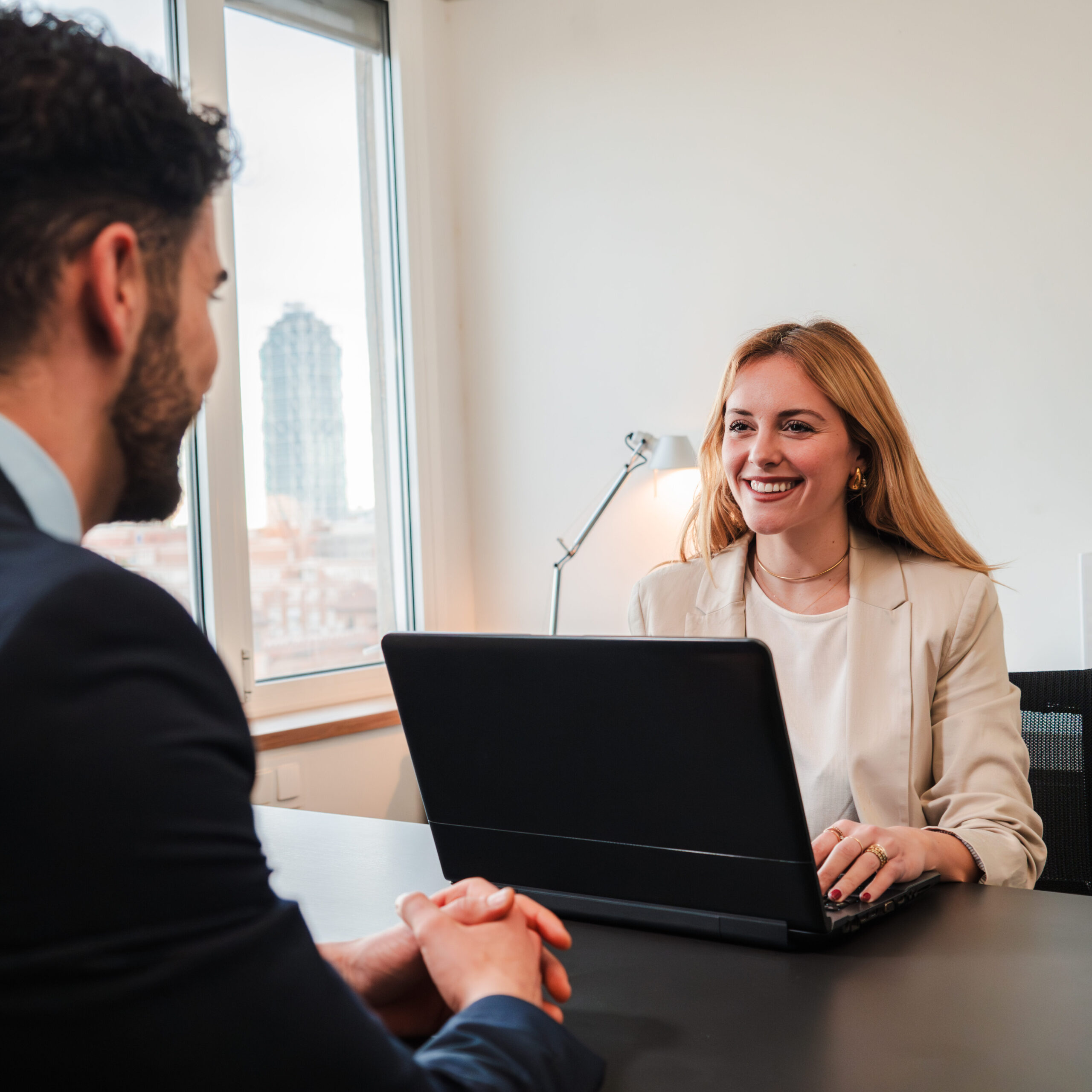AI w HR – rekruterka rozmawia z kandydatem podczas rozmowy kwalifikacyjnej, na biurku laptop