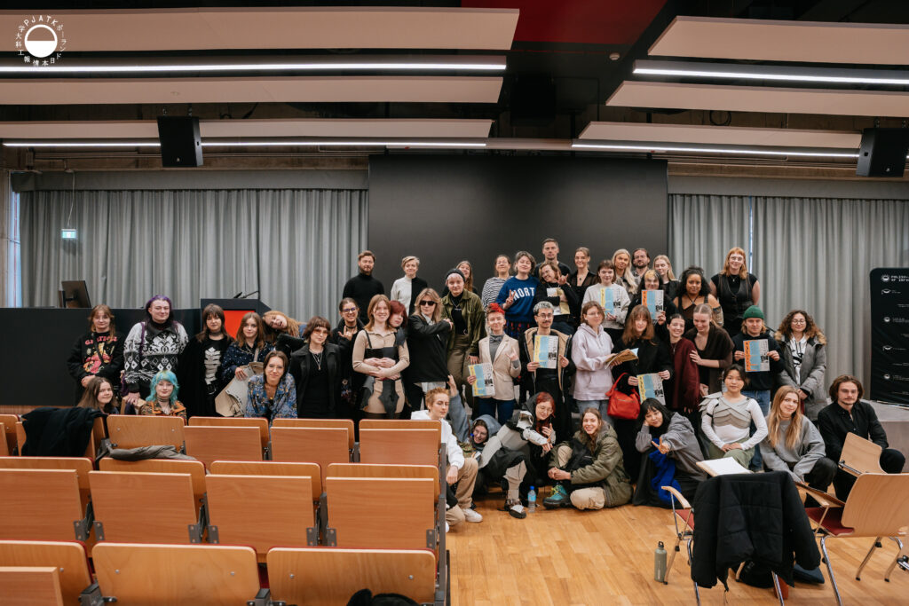 Uczestnicy międzynarodowych warsztatów Creativity pozują do wspólnego zdjęcia w sali wykładowej po zakończeniu zajęć.