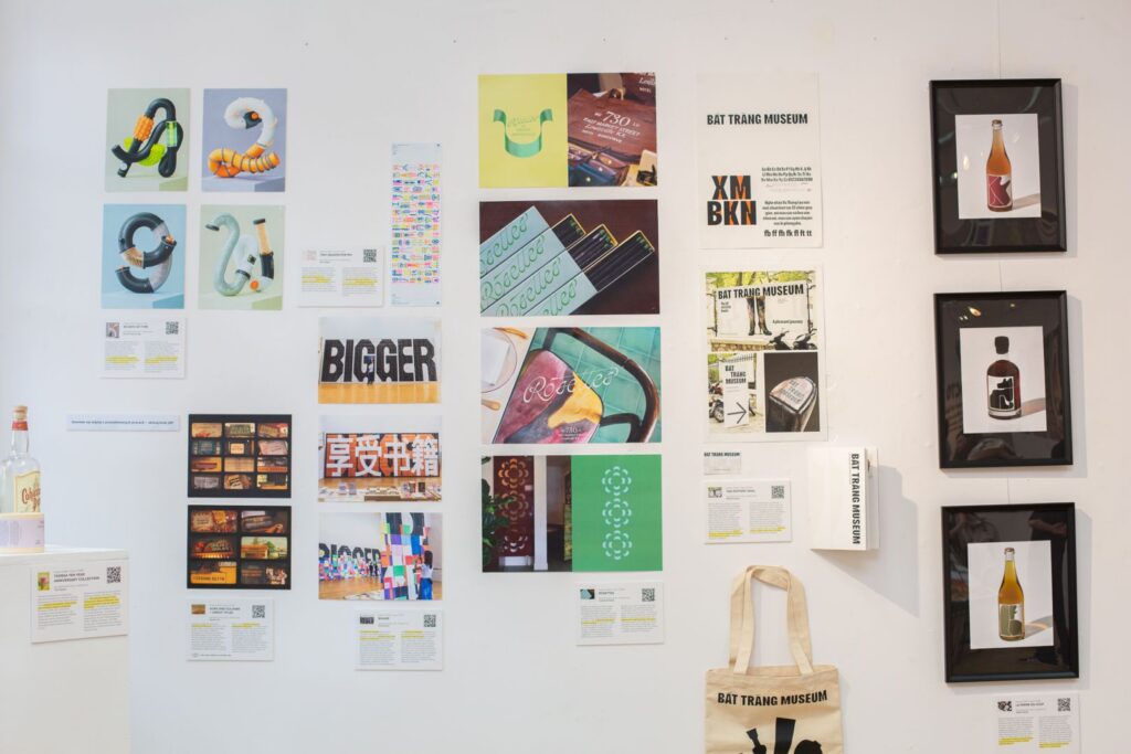 Ściana galerii z prezentacją projektów graficznych, plakatów i materiałów wizualnych.