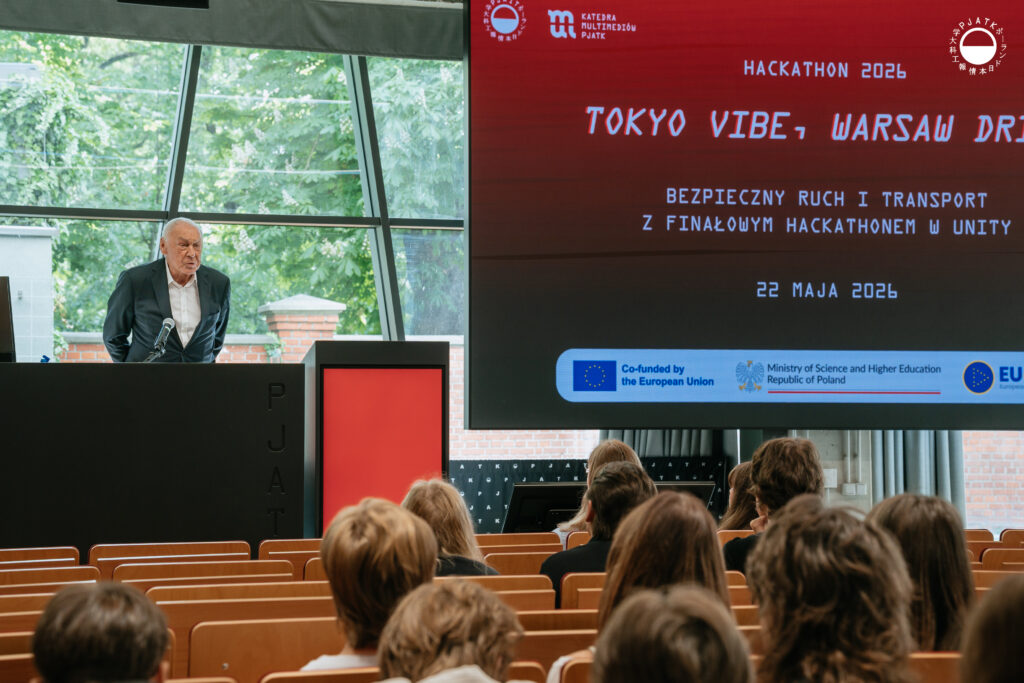 Zdjęcia z wydarzenia „Tokyo vibe, Warsaw drive” w PJATK. Uczestnicy biorą udział w wykładach oraz testują symulator jazdy samochodem przygotowany w ramach projektu Katedry Multimediów. Na fotografiach widać osoby korzystające z kierownicy i ekranów symulatora, widok wirtualnej trasy, prelegentów występujących w auli oraz uczestników spotkania.