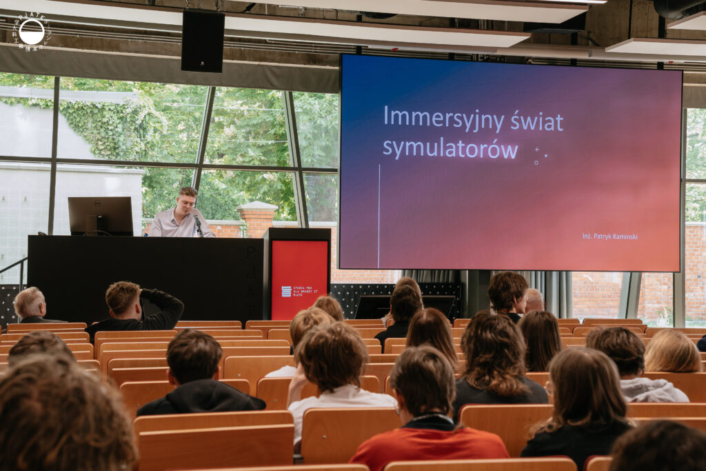 Zdjęcia z wydarzenia „Tokyo vibe, Warsaw drive” w PJATK. Uczestnicy biorą udział w wykładach oraz testują symulator jazdy samochodem przygotowany w ramach projektu Katedry Multimediów. Na fotografiach widać osoby korzystające z kierownicy i ekranów symulatora, widok wirtualnej trasy, prelegentów występujących w auli oraz uczestników spotkania.
